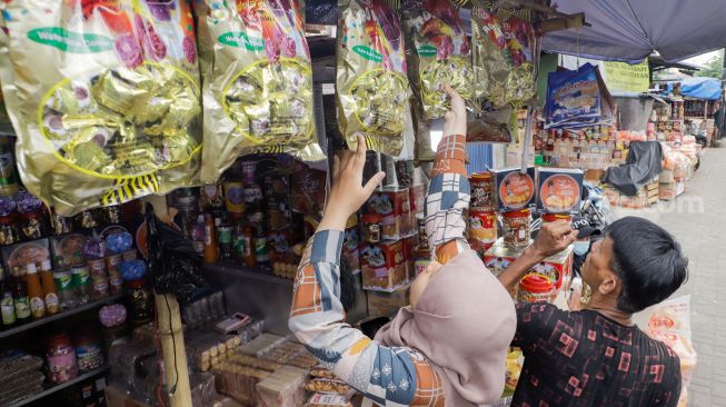 Pembeli memilih kue kaleng di salah satu toko kue kering di kawasan Ciracas, Jakarta Timur, Kamis (20/4/2023). [Suara.com/Alfian Winanto]