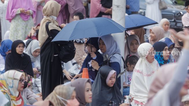 Warga jamaah Muhammadiyah mendengarkan khotbah usai melaksanakan salat Idul Fitri 1444 Hijriah di halaman Pusat Dakwah Muhammadiyah, Menteng, Jakarta Pusat, Jumat (21/4/2023). [Suara.com/Alfian Winanto]