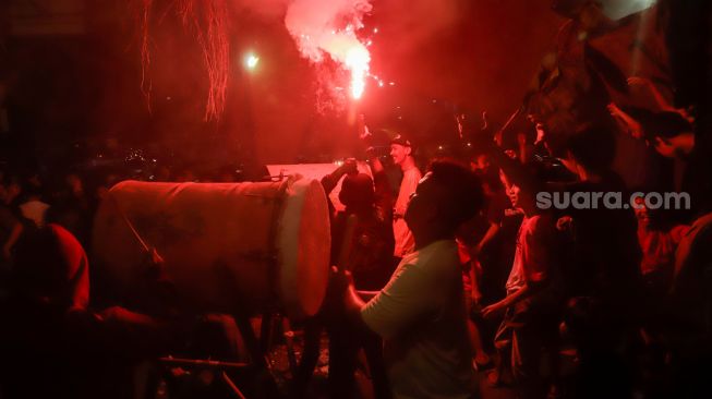 Warga menabuh bedug untuk merayakan Malam Takbiran menyambut Hari Raya Idul Fitri di Kawasan Manggarai, Jakarta, Jumat (21/4/2023). [Suara.com/Alfian Winanto]