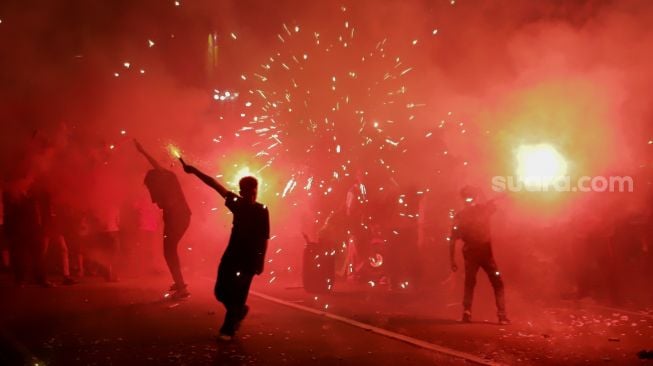 Warga menyalakan suar untuk merayakan Malam Takbiran menyambut Hari Raya Idul Fitri di Kawasan Manggarai, Jakarta, Jumat (21/4/2023). [Suara.com/Alfian Winanto]