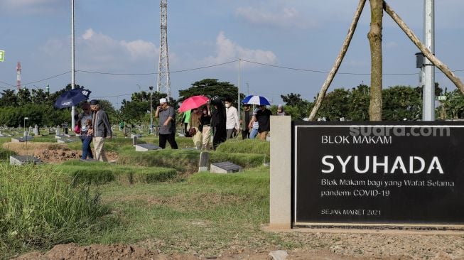 Warga melakukan ziarah kubur di Tempat Pemakaman Khusus Covid-19 TPU Rorotan, Jakarta Utara, Sabtu (22/4/2023). [Suara.com/Alfian Winanto]