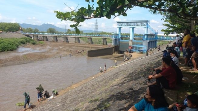 Warga tengah mencari ikan di aliran irigasi Dam Colo Nguter. [timlo.net/desy]