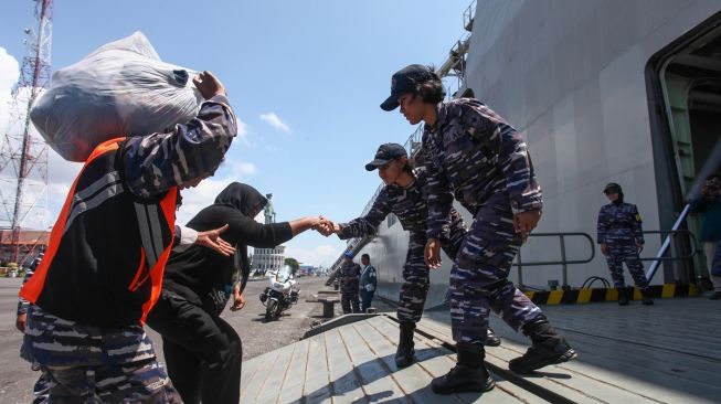 Personel TNI AL membantu pemudik masuk ke KRI Banjarmasin-592 di Koarmada II, Surabaya, Jawa Timur, Selasa (25/4/2023). [ANTARA FOTO/Didik Suhartono]