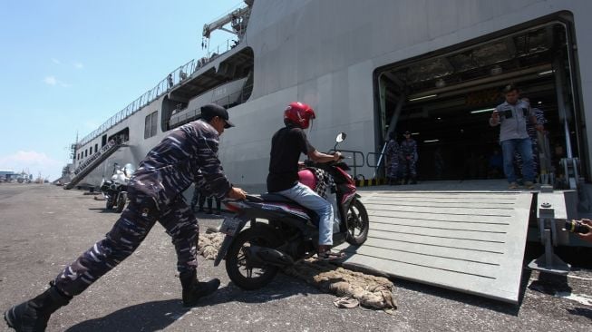 Personel TNI AL membantu pemudik masuk ke KRI Banjarmasin-592 di Koarmada II, Surabaya, Jawa Timur, Selasa (25/4/2023). [ANTARA FOTO/Didik Suhartono]