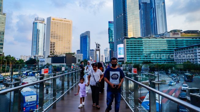 Warga berwisata di Anjungan Halte Transjakarta Bundaran HI, Jakarta Pusat, Kamis (27/4/2023). [Suara.com/Alfian Winanto]