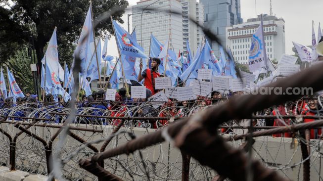Sejumlah massa buruh melakukan aksi unjuk rasa di kawasan Patung Kuda Arjuna Wiwaha, Jakarta Pusat, Senin (1/5/2023). [Suara.com/Alfian Winanto]