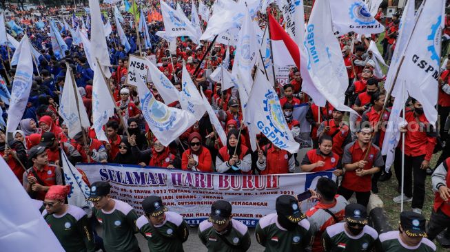 Sejumlah massa buruh melakukan aksi unjuk rasa di kawasan Patung Kuda Arjuna Wiwaha, Jakarta Pusat, Senin (1/5/2023). [Suara.com/Alfian Winanto]