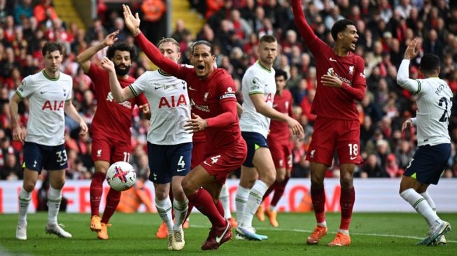 Bek Liverpool asal Belanda Virgil van Dijk (Tengah) melakukan protes kepada wasit atas pelanggaran handball di akhir babak pertama selama pertandingan pekan ke-34 Liga Inggris 2022-2023 antara Liverpool vs Tottenham Hotspur di Anfield di Liverpool, barat laut Inggris pada 30 April 2023.Paul ELLIS / AFP.