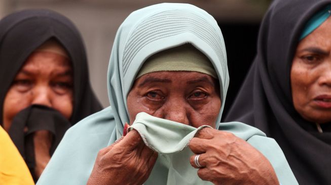 Keluarga korban tragedi Simpang KAA mengusap air mata usai pembacaan surat terbuka untuk Presiden Joko Widodo saat peringatan mengenang 24 tahun tragedi Simpang KAA di Tugu Keadilan Dewantara, Aceh Utara, Aceh, Rabu (3/5/2023). [ANTARA FOTO/Rahmad].