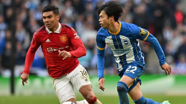 Winger Brighton, Kaoru Mitoma (kanan) dibayangi gelandang Manchester United, Casemiro pada laga semifinal Piala FA di Wembley, London, Inggris, 23 April 2023. [Glyn KIRK / AFP]