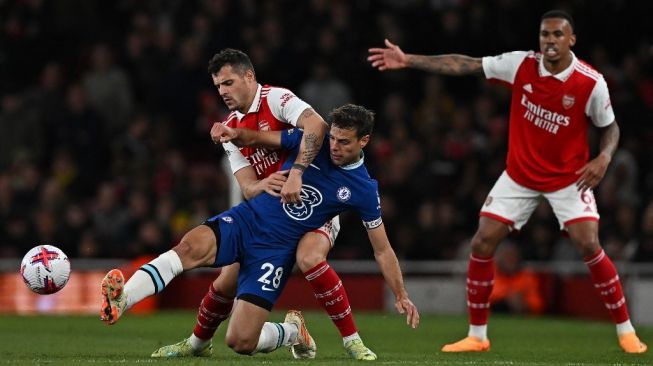 Gelandang Arsenal asal Swiss Granit Xhaka (kiri) bersaing dengan bek Chelsea asal Spanyol Cesar Azpilicueta pada pertandingan pekan ke-34 Liga Inggris 2022-2023 antara Arsenal vs Chelsea di Stadion Emirates, di London, pada 2 Mei 2023. Arsenal memenangkan pertandingan 3-1.Ben Stansall / AFP