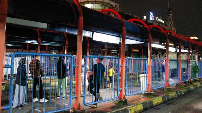 Penumpang menunggu bus transjakarta di Terminal Blok M, Jakarta, Rabu (3/5/2023). [Suara.com/Alfian Winanto]