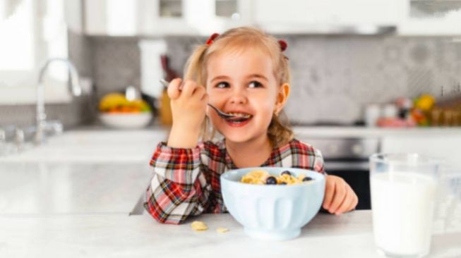 Ilustración de un niño comiendo (pexels/bulatovic)