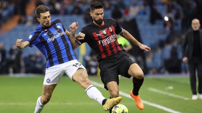 Striker AC Milan, Olivier Giroud (kanan) berduel dengan bek Inter Milan, Francesco Acerbi dalam laga Piala Super Italia di King Fahd International Stadium, Riyadh, Arab Saudi pada 18 Januari 2023.[Giuseppe CACACE / AFP]