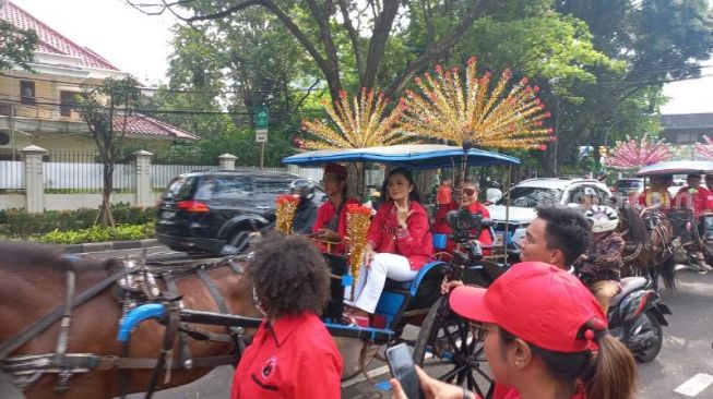 Artis Krisdayanti ikut naik delman dalam parade budaya yang digelar PDIP dalam rangka pendaftaran calon legislatif ke kantor KPU RI, Jakarta Pusat, Kamis (11/5/2023). (Suara.com/Bagaskara)