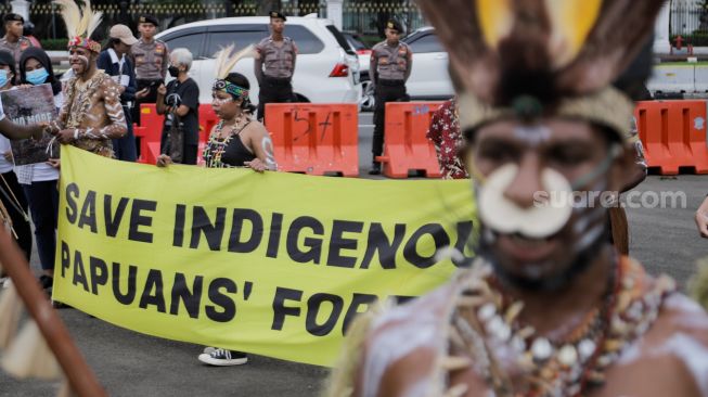 Sejumlah perwakilan masyarakat Suku Awyu Papua melakukan aksi di seberang Istana Merdeka, Jakarta Pusat, Kamis (11/5/2023). [Suara.com/Alfian Winanto]