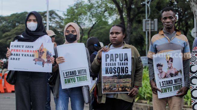 Sejumlah perwakilan masyarakat Suku Awyu Papua melakukan aksi di seberang Istana Merdeka, Jakarta Pusat, Kamis (11/5/2023). [Suara.com/Alfian Winanto]