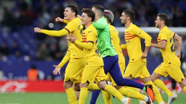 Para pemain Barcelona melakukan selebrasi usai mengunci gelar juara liga Spanyol 2022-2023 setelah pertandingan pekan ke-25 Liga Spanyol antara RCD Espanyol vs FC Barcelona di Stadion RCDE di Cornella de Llobregat pada 14 Mei 2023. Barcelona memenangkan gelar Liga Spanyol ke-27 atau yang pertama sejak 2019 pasca  mengalahkan Espanyol 4 -2. Raksasa Catalan merebut gelar juara dari Real Madrid dengan kemenangan derby yang tegas, di mana gol-gol mereka dicetak Robert Lewandowski (dua gol), di samping gol Alejandro Balde dan Jules Kounde.Lluis GEN / AFP.