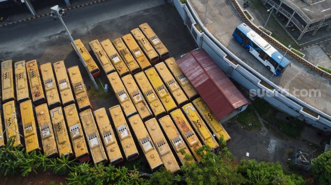 Deretan bus TransJakarta yang rusak dan tidak terawat terparkir di kawasan Terminal Terpadu Pulo Gebang, Jakarta Timur, Senin (15/5/2023). [Suara.com/Alfian Winanto]