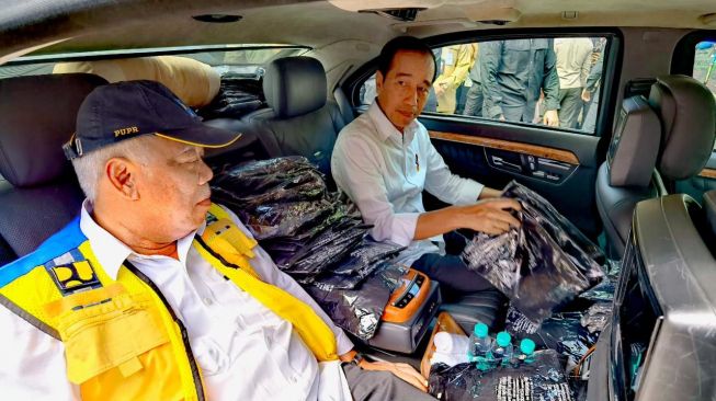 Tumpukan kaos hitam bergambarkan wajah Presiden Joko Widodo atau Jokowi memadati kursi penumpang mobil kepresidenan RI 1 saat Jokowi kunjungan kerja ke Provinsi Jambi, Selasa (16/5/2023). (Agus Suparto)