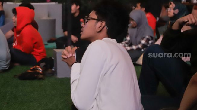 Sejumlah warga menyaksikan pertandingan final cabang olahraga sepak bola antara Indonesia melawan Thailand di Green Cafe Semanggi, Jakarta, Selasa (16/5/2023). [Suara.com/Alfian Winanto]