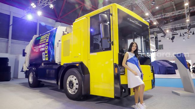 Model berpose di dekat truk listrik Aquila milik PT Mobil Anak Bangsa (MAB) yang dipamerkan pada Periklindo Electric Vehicle Show (PEVS) 2023 di JIExpo Kemayoran, Jakarta, Rabu (17/5/2023). [Suara.com/Alfian Winanto]