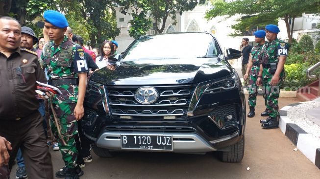 Kejaksaan Agung turut menyita sejumlah barang di mobil Toyota Fortuner yang ditumpangi Menkominfo Johnny G Plate saat menjalani  pemeriksaan kasus korupsi proyek BTS BAKTI Kominfo. (Suara.com/M Yasir) 