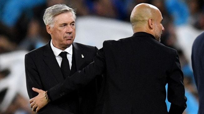 Real Madrid Italy coach Carlo Ancelotti (L) congratulates Manchester City's Spanish manager Pep Guardiola after the second leg of the 2022-2023 Champions League semi-final second leg match between Manchester City vs Real Madrid at the Etihad Stadium in Manchester, north west England, on May 17 2023. Manchester City won the game 4-0.Oli SCARFF/AFP