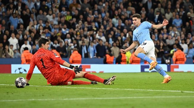 Manchester City's Argentinian striker Julian Alvarez (right) scores the team's fourth goal past Real Madrid's Belgian goalkeeper Thibaut Courtois during the second leg of the 2022-2023 Champions League semi-final between Manchester City vs Real Madrid at the Etihad Stadium in Manchester, north west England, on 17 May 2023. Manchester City won the game 4-0. Paul ELLIS / AFP