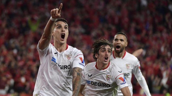 Penyerang Sevilla asal Argentina Erik Lamela (kiri) merayakan gol kedua timnya saat pertandingan leg kedua semifinal antara Sevilla vs Juventus di Stadion Ramon Sanchez Pizjuan di Seville pada 18 Mei 2023.CRISTINA QUICLER / AFP.