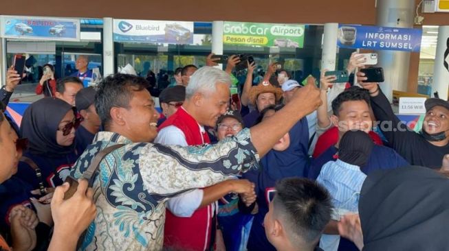 Bakal calon presiden dari PDI Perjuangan (PDIP) Ganjar Pranowo disambut meriah oleh pendukung saat tiba di Palembang, Sumatera Selatan pada Sabtu (20/5/2023). (Suara.com/Bagaskara)