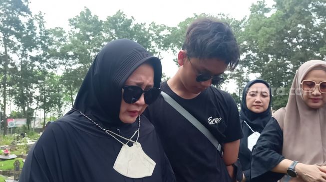 Feni, keponakan Eeng Saptahadi (jilbab hitam) bersama Yani (jilbab Coklat) di TPU Cipenjo, Cileungsi, Bogor Jawa Barat pada Senin (22/5/2023) [Suara.com/Rena Pangesti]