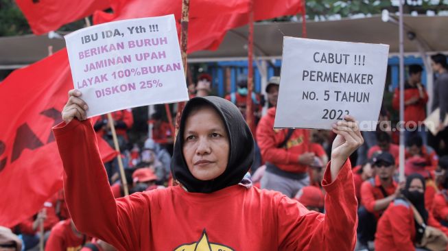 Massa dari berbagai serikat buruh/pekerja melakukan aksi unjuk rasa di depan Gedung Kementerian Ketenagakerjaan, Jakarta, Selasa (23/5/2023). [Suara.com/Alfian Winanto]
