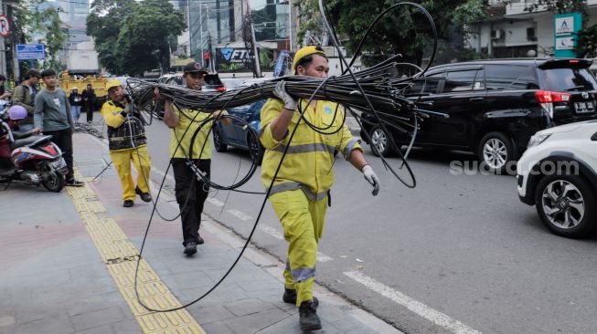 Petugas Dinas Bina Marga DKI Jakarta melakukan penataan kabel utilitas di sekitar Jalan Haji Agus Salim, Jakarta Pusat, Rabu (24/5/2023). [Suara.com/Alfian Winanto]