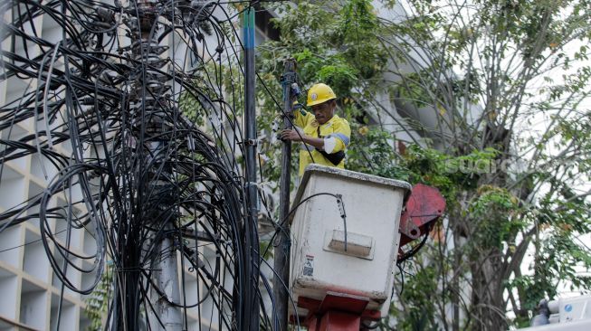 Petugas Dinas Bina Marga DKI Jakarta melakukan penataan kabel utilitas di sekitar Jalan Haji Agus Salim, Jakarta Pusat, Rabu (24/5/2023). [Suara.com/Alfian Winanto]