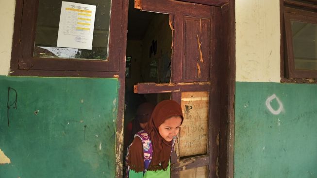 Murid keluar dari ruang kelas yang rusak di SD Negeri Tanjung Ilir, Sayar, Kota Serang, Banten, Sabtu (27/5/2023).[ANTARA FOTO/Asep Fathulrahman].