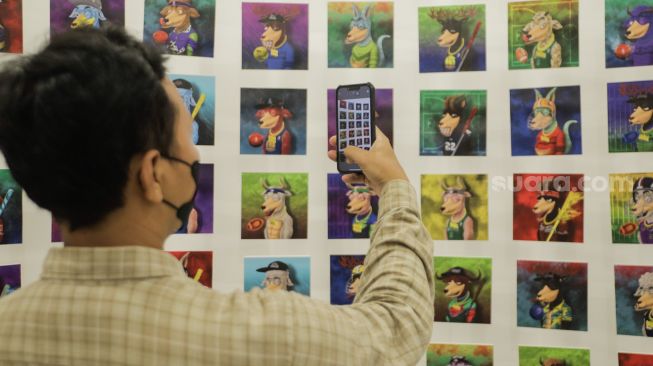 Pengunjung mengamati karya dalam pameran bertajuk Non-Fungible Token (NFT) digital art di NFTone Gallery, Jakarta, Rabu (31/5/2023). [Suara.com/Alfian Winanto]