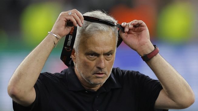 Pelatih AS Roma asal Portugal Jose Mourinho melepas medali runner-up setelah pertandingan final Liga Europa 2022-2023 antara Sevilla vs AS Roma di Puskas Arena di Budapest pada 31 Mei 2023. AS Roma gagal juara setelah kalah adu penalti dengan skor 1-4 setelah bermain imbang 1-1 selama 120 menit.Aneh ANDERSEN / AFP