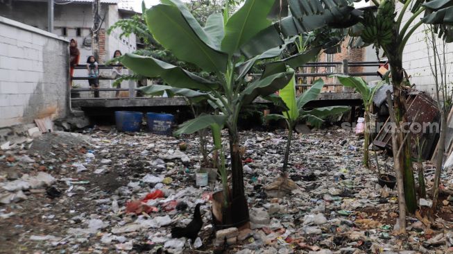 Tumpukan sampah memenuhi Sodetan kali yang terbengkalai di Kampung Sumur, Klender, Jakarta Timur, Kamis (1/6/2023). [Suara.com/Alfian Winanto]