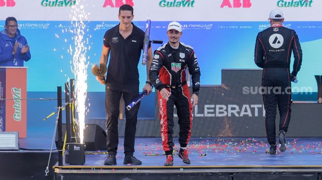 Pebalap Pascal Wehrlein (tengah) dari TAG Heuer Porsche Formula E Team berselebrasi usai berhasil keluar sebagai juara seri balapan Formula E Jakarta 2023 yang dihelat di Jakarta International e-Prix Circuit, Jakarta Utara, Sabtu (3/5/2023). [Suara.com/Alfian Winanto]