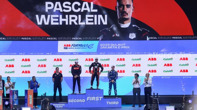 Pebalap Pascal Wehrlein (tengah) dari TAG Heuer Porsche Formula E Team berselebrasi usai berhasil keluar sebagai juara seri balapan Formula E Jakarta 2023 yang dihelat di Jakarta International e-Prix Circuit, Jakarta Utara, Sabtu (3/5/2023). [Suara.com/Alfian Winanto]
