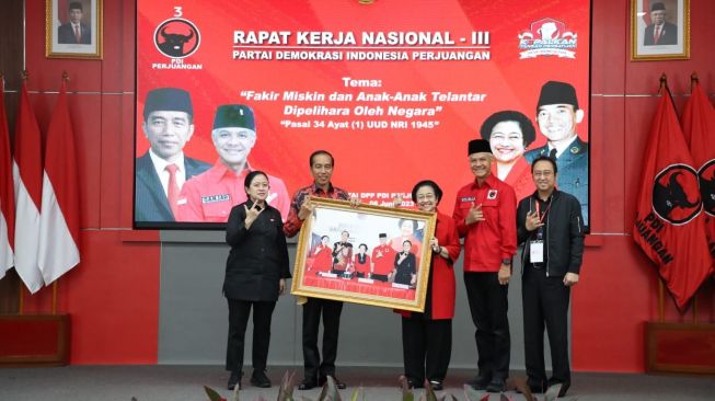 Presiden Jokowi menerima foto dari Ketum PDIP Megawati Soekarnoputri saat Rakernas III PDIP di Sekolah Partai, Lenteng Agung, Jaksel pada Selasa (6/6/2023). [DOK DPP PDIP]