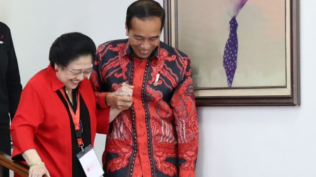 Presiden Joko Widodo (kanan) memegang tangan Ketua Umum PDI Perjuangan Megawati Sukarnoputri (kiri) saat berjalan bersama di sela berlangsungnya Rakernas PDI Perjuangan di Jakarta, Selasa (6/6/2023). [ANTARA FOTO/Monang Sinaga].