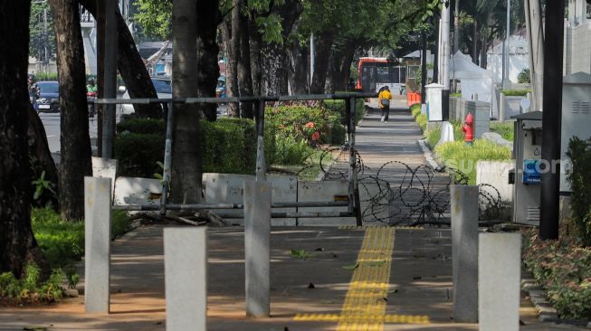Sejumlah pejalan kaki melintasi trotoar di depan kantor Kedutaan Besar Amerika Serikat (Kedubes AS) di Jalan Merdeka Selatan, Jakarta, Rabu (7/6/2023). [Suara.com/Alfian Winanto]