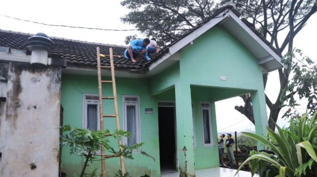 Warga memperbaiki rumah yang rusak akibat angin puting beliung di Kecamatan Baleendah, Kabupaten Bandung, Jawa Barat, Selasa (6/6/2023). [Humas Pemkab Bandung]