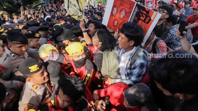 Sejumlah buruh dan aktivis yang menggelar aksi unjuk rasa untuk mendukung Haris Azhar dan Fatia terlibat bentrokan dengan pihak kepolisian yang berjaga di depan Pengadilan Negeri Jakarta Timur, Kamis (8/6/2023). [Suara.com/Alfian Winanto]