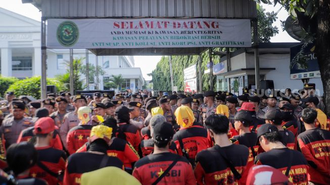 Sejumlah buruh dan aktivis yang menggelar aksi unjuk rasa untuk mendukung Haris Azhar dan Fatia terlibat bentrokan dengan pihak kepolisian yang berjaga di depan Pengadilan Negeri Jakarta Timur, Kamis (8/6/2023). [Suara.com/Alfian Winanto]