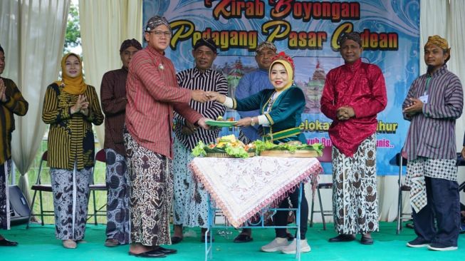 Wakil Bupati Sleman, Danang Maharsa (kiri) memberikan tumpeng kepada perwakilan pedagang sebagai simbolisasi relokasi pedagang Pasar Godean, Sabtu (10/6/2023). (Dok.Istimewa)