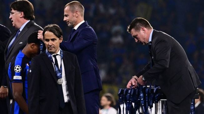 Pelatih Inter Milan, Simone Inzaghi menerima medali runner-up usai laga final Liga Champions kontra Manchester City di Ataturk Olympic Stadium, Istanbul, Turki, Minggu (11/6/2023) dini hari WIB. [Marco BERTORELLO / AFP]