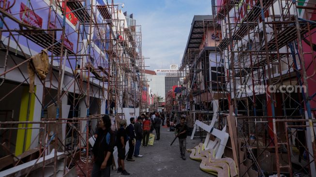 Pekerja menyelesaikan pembangunan tenant untuk acara Jakarta Fair Kemayoran (JFK) di JIExpo Kemayoran Jakarta, Senin (12/6/2023). [Suara.com/Alfian Winanto]